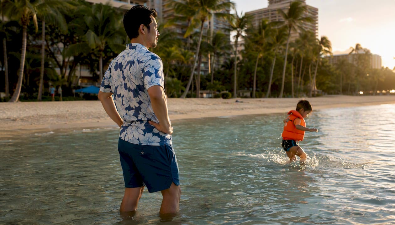 Mother standing in shallow surf actively supervising child