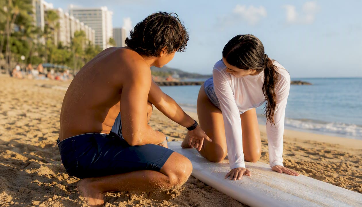 Instructor coaching foot placement on waxed board