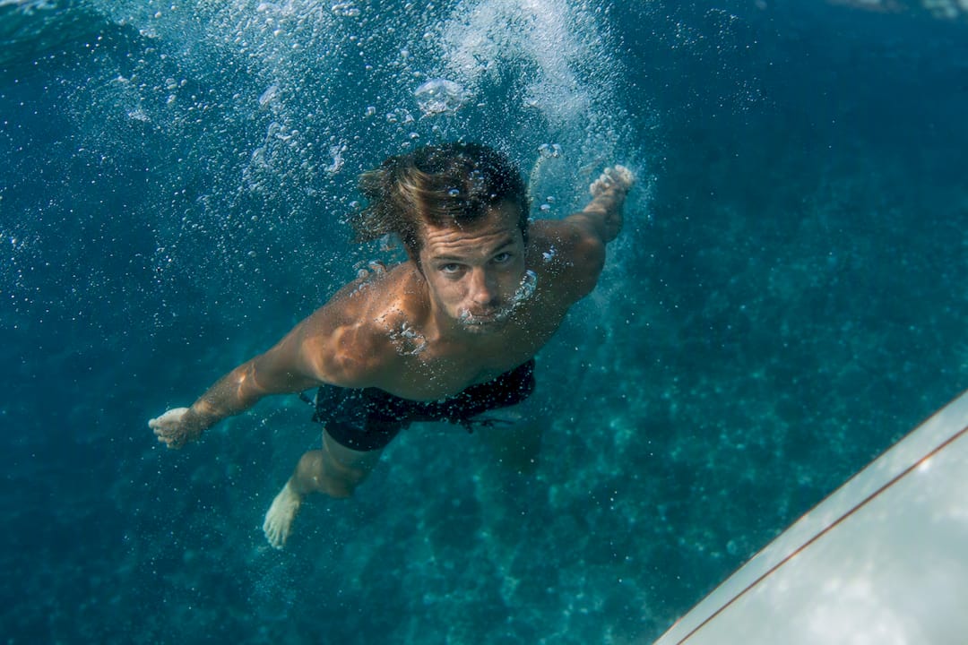 Surfer underwater holding breath after duck dive
