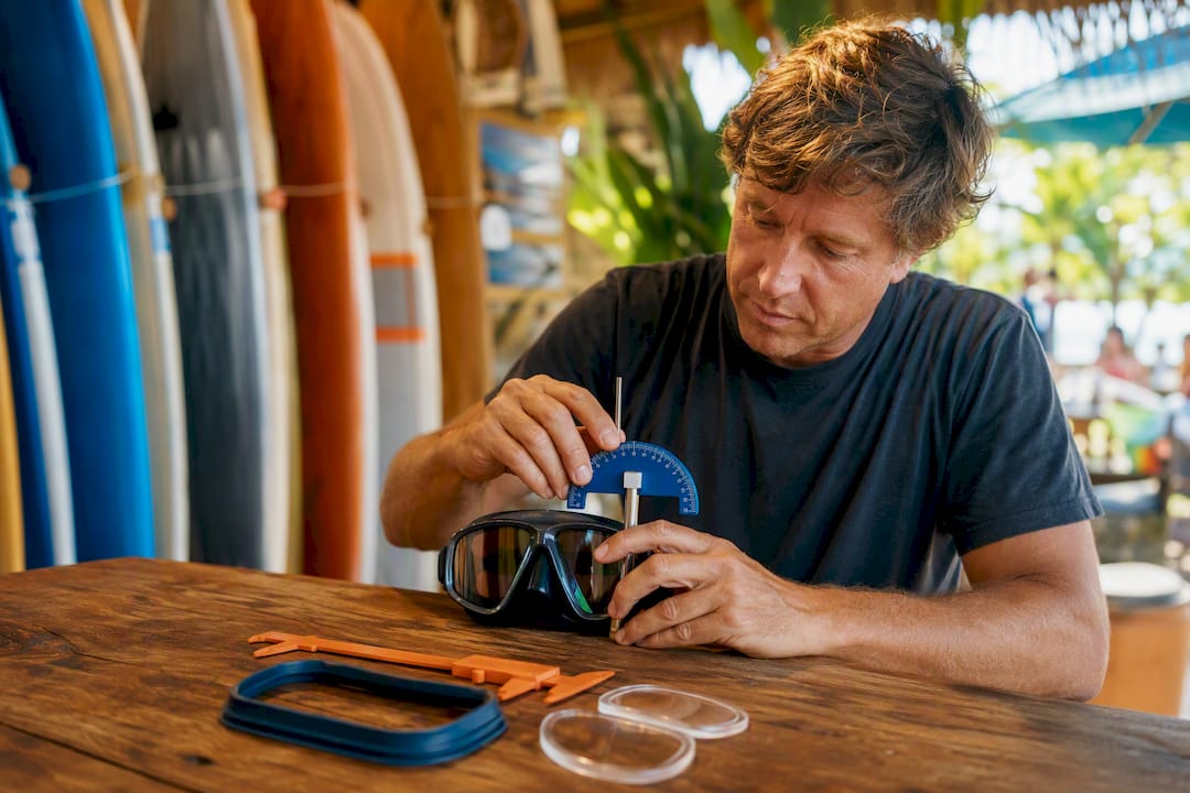 Optician adjusting surf goggles curvature