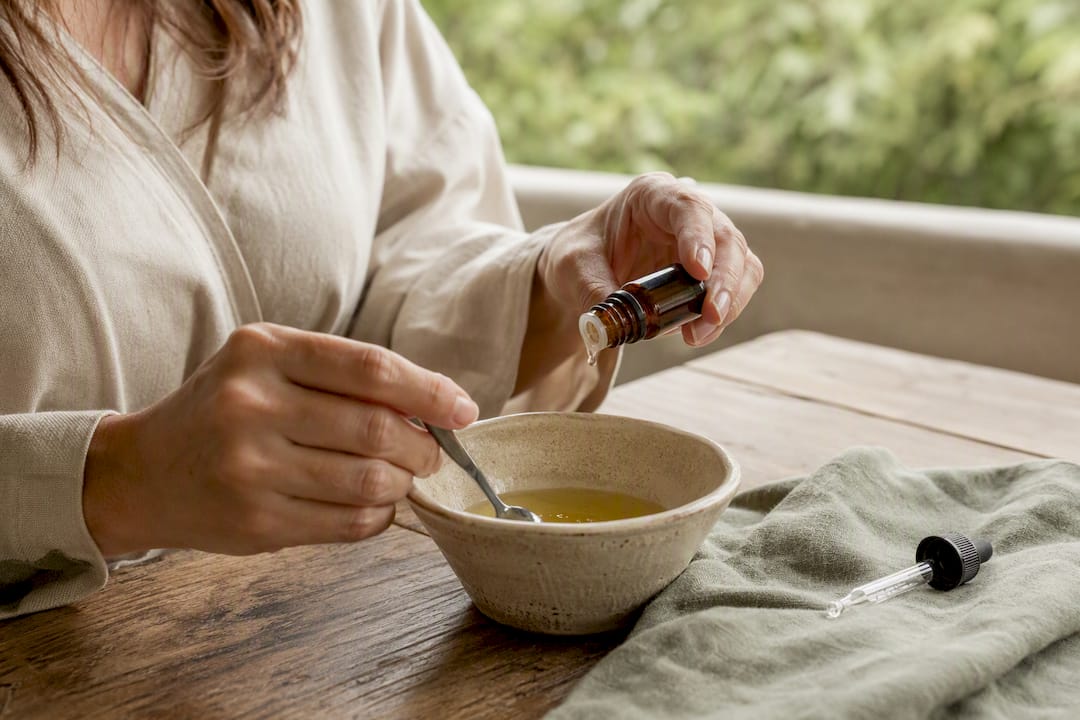 Hands mixing diluted essential oils