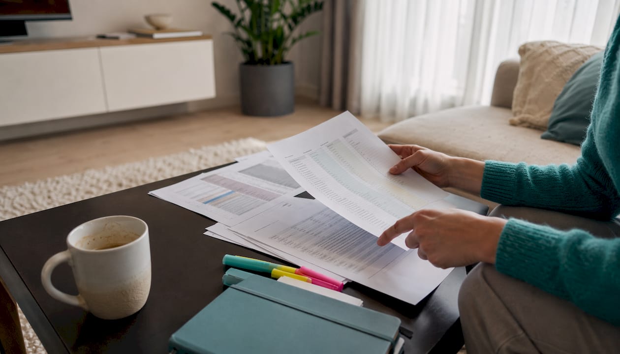 Hands typing near printed gift registry comparison charts