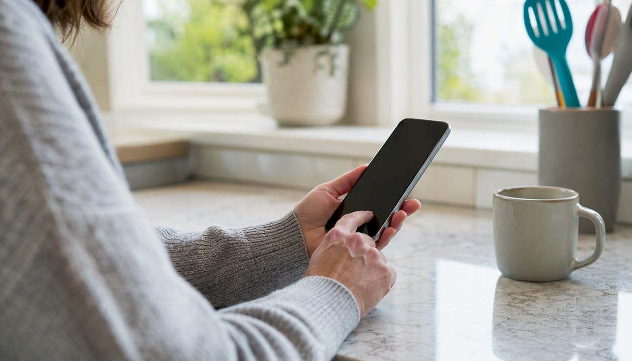 Hands adding item to wishlist on phone