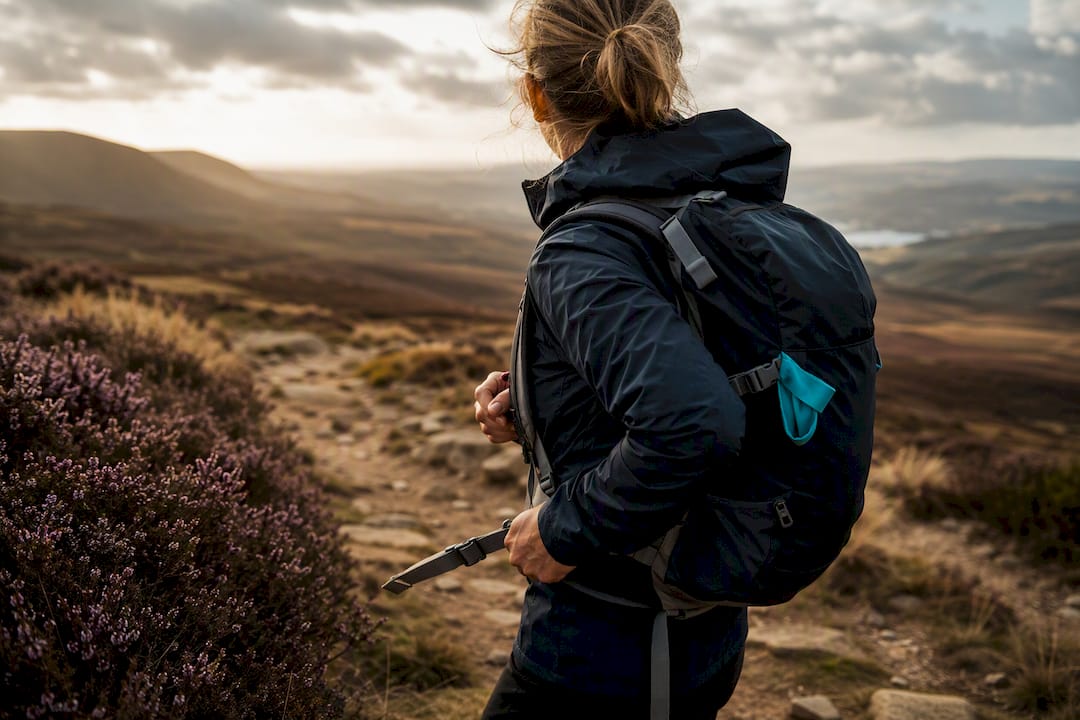Hiker checking practical walking kit on moorland