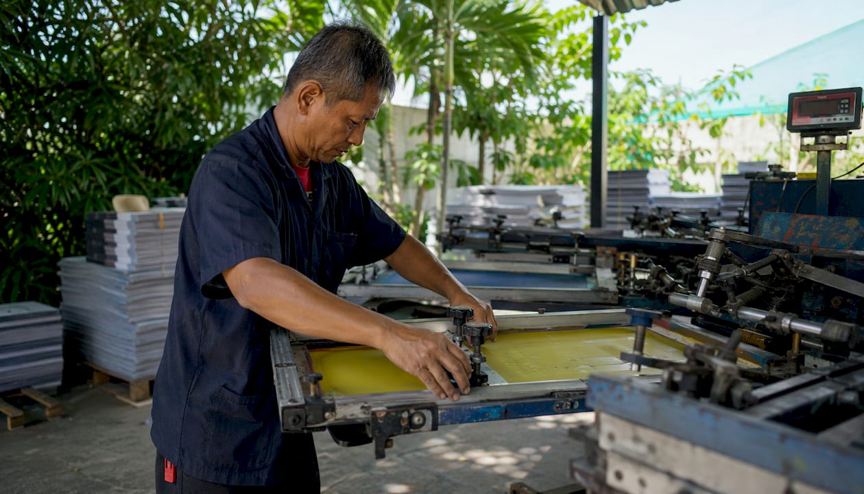 Technician adjusting screen printing machine