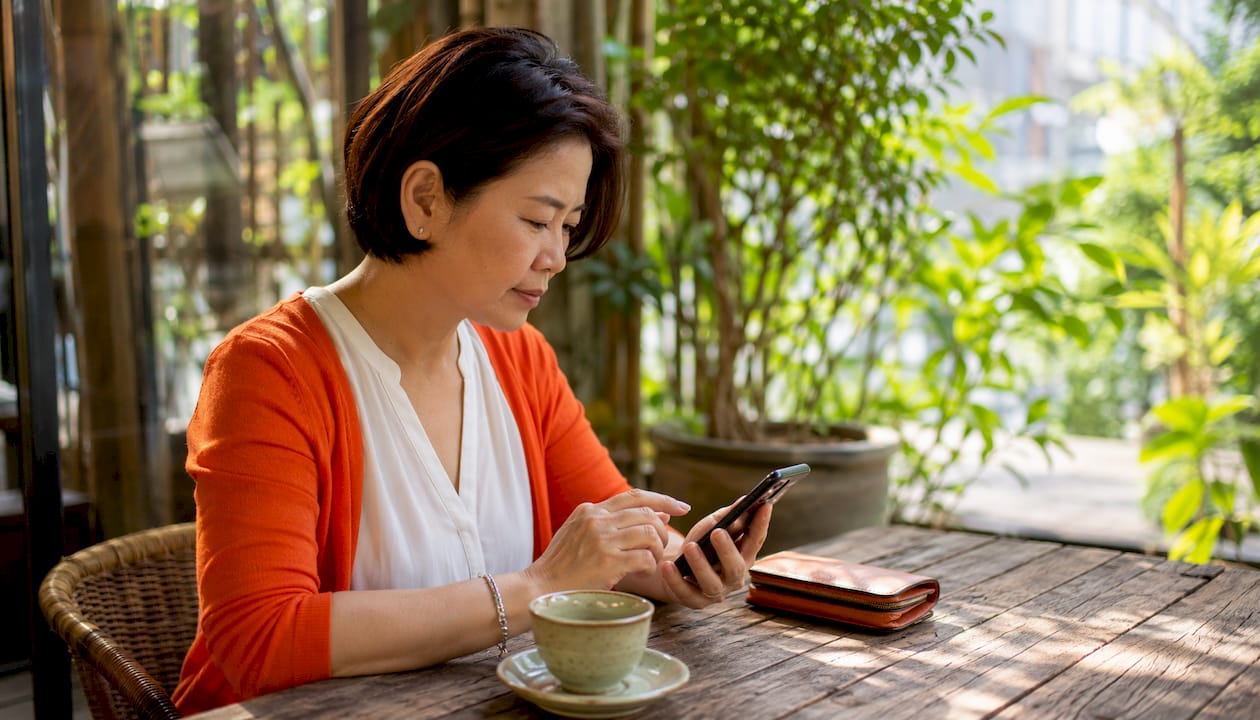Woman using smartphone at cafe table