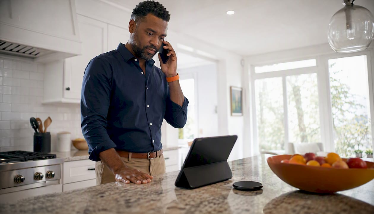 Man using smartphone and tablet for VoIP call