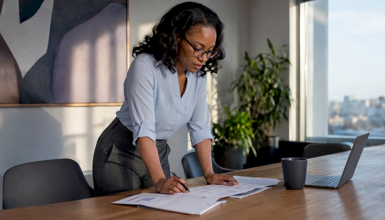 Woman reviewing AI governance compliance documents