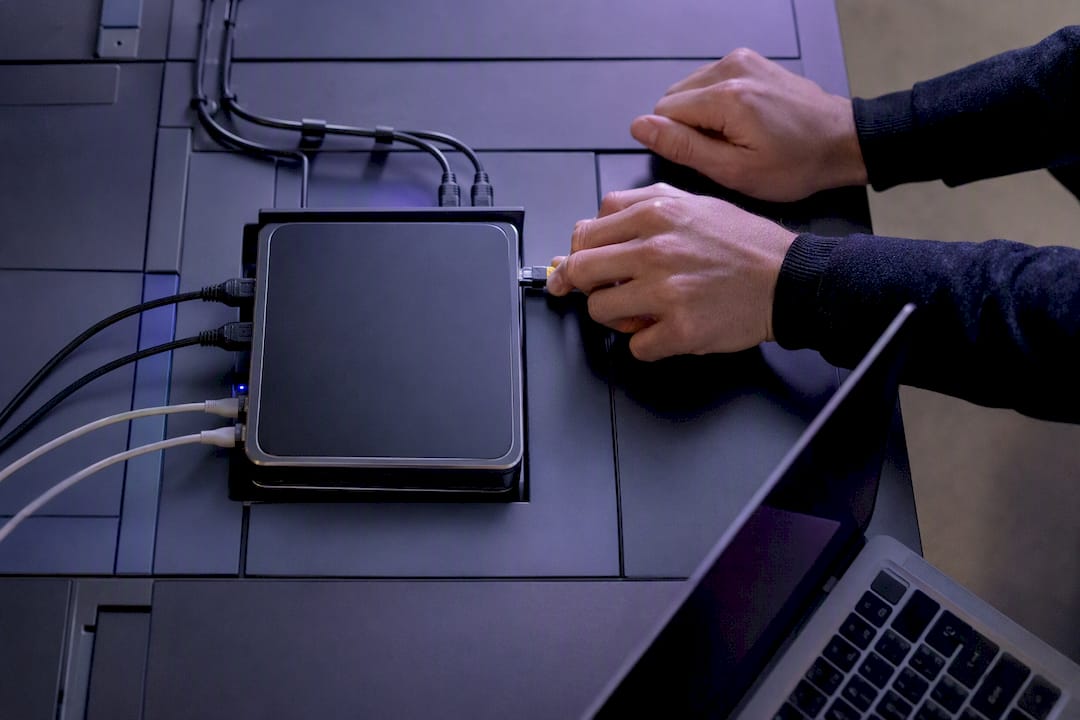 Hands plugging network cable into IT control panel