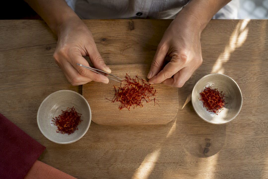 Artisan sélectionnant des filaments de safran