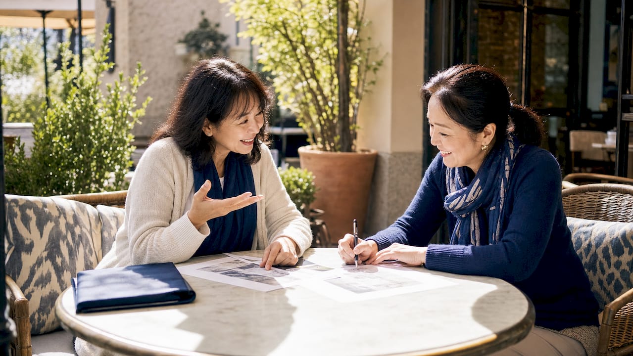 Woman reviewing printed travel itinerary at home table
