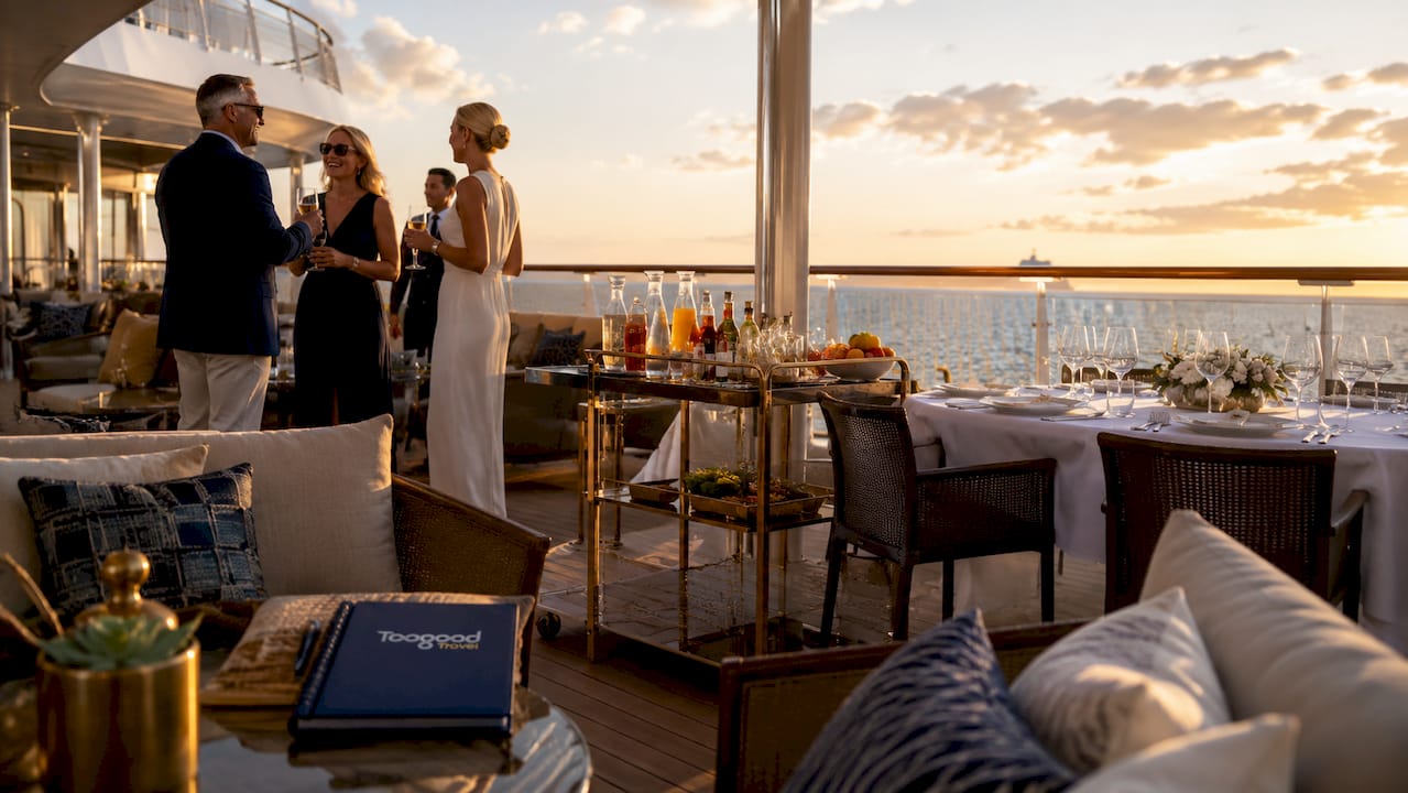Outdoor cruise ship deck with dining setup and ocean view
