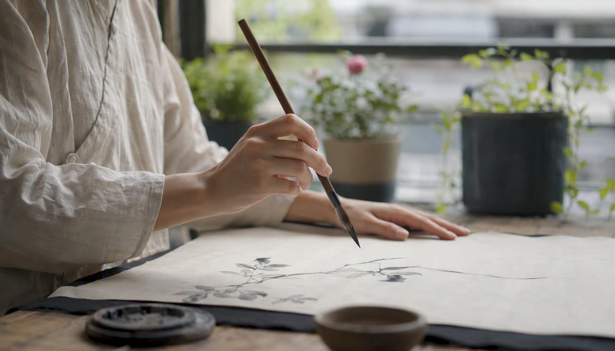 Hands practicing core Sumi-e brush strokes