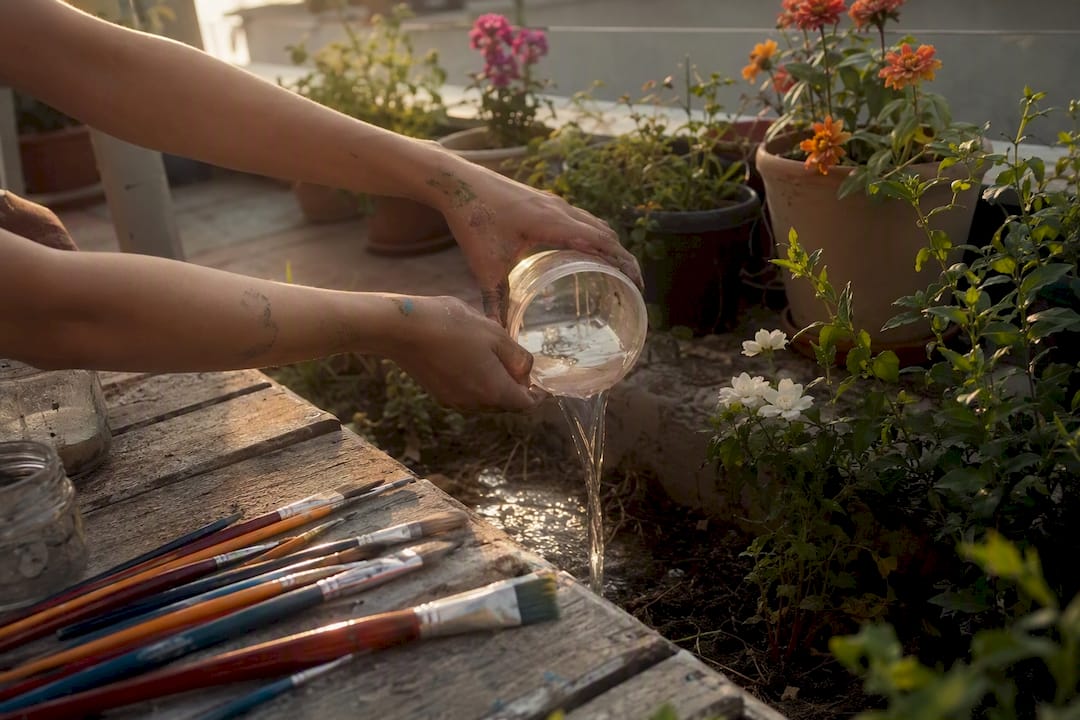 Hands pouring clear rinse water outdoors