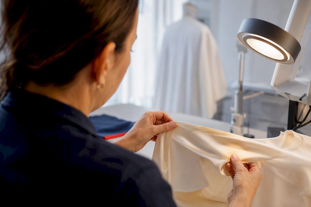 Cleaner inspecting delicate stained garment