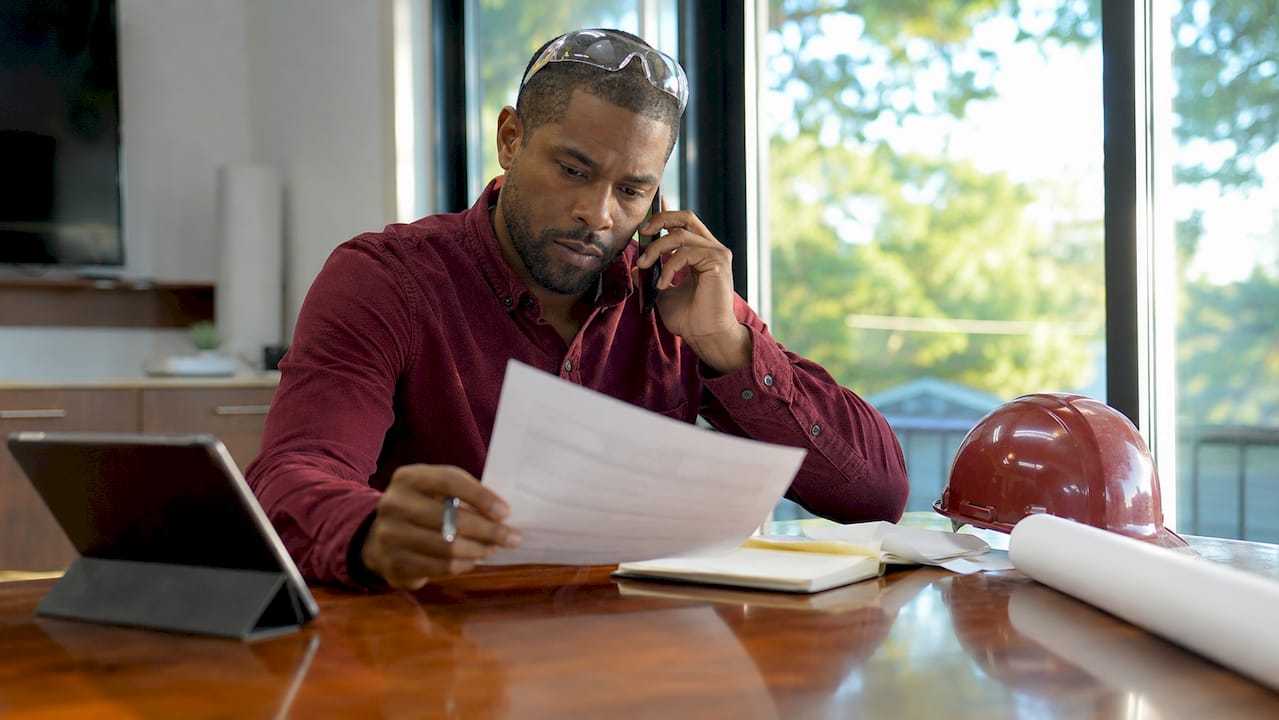 Contractor verifying insurance certificate on phone