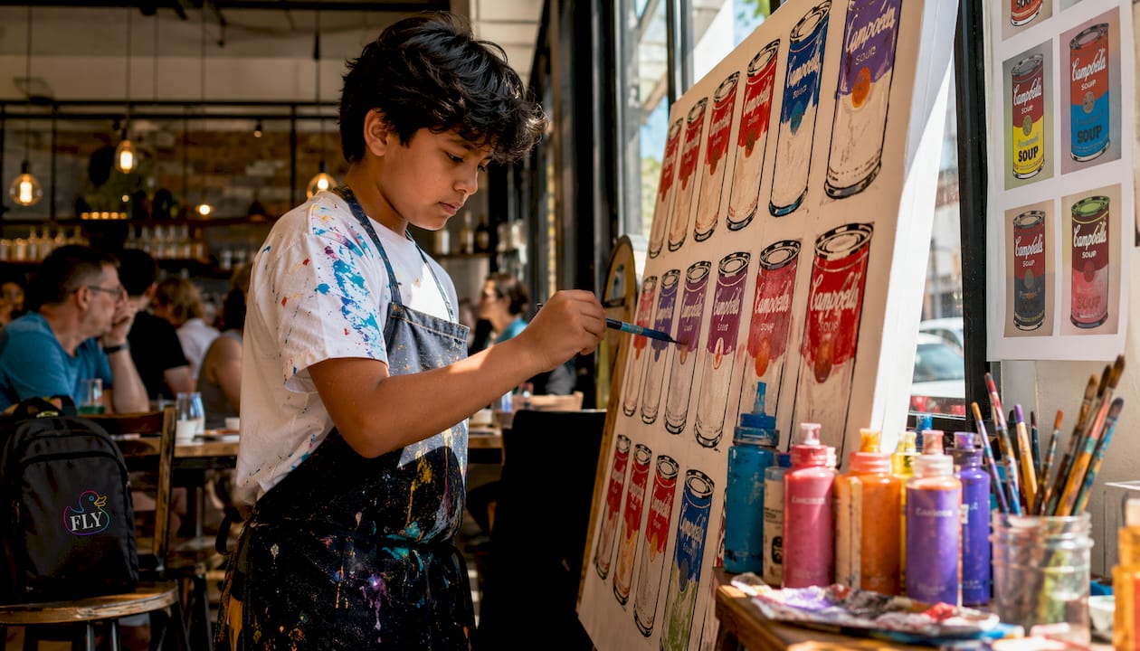 Child painting Warhol-style soup cans