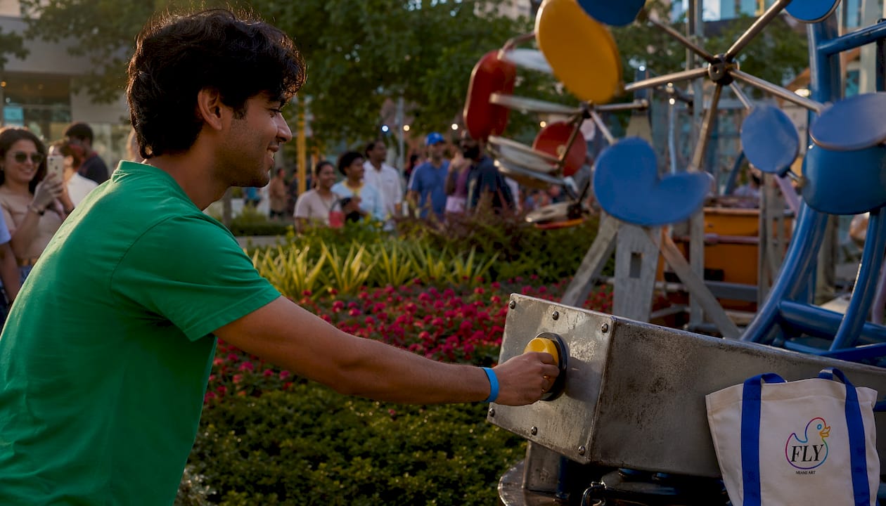 Hand pressing button on mechanized sculpture