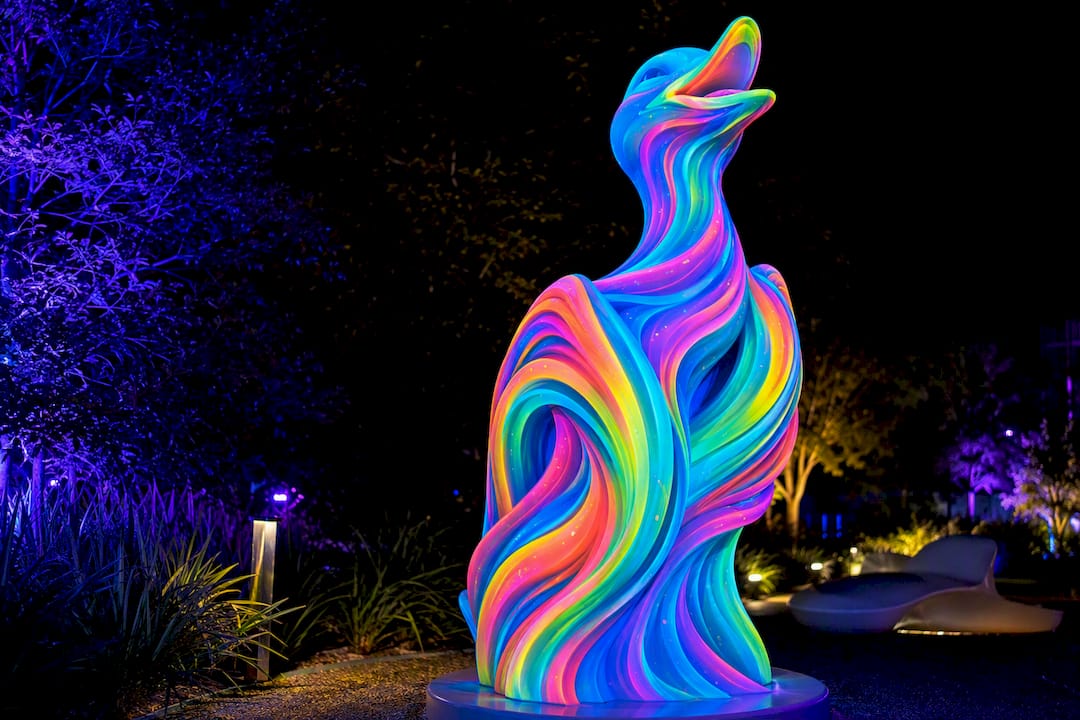 UV-reactive sculpture glowing under blacklight at night