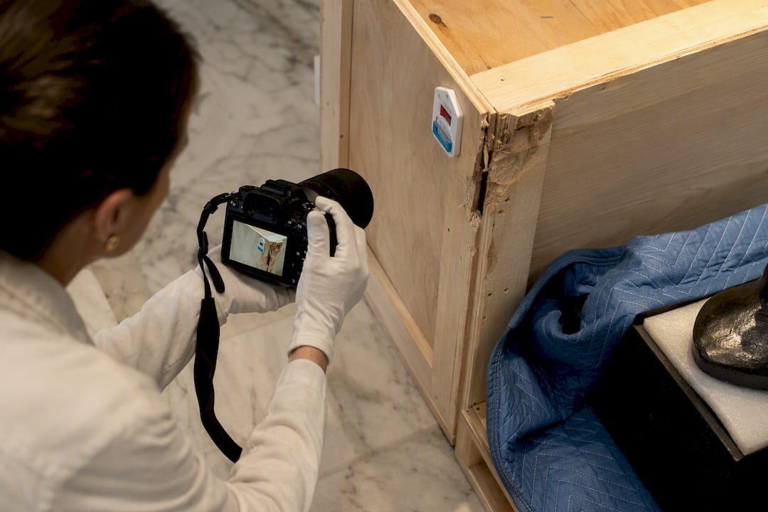 Crate damage being documented during sculpture delivery