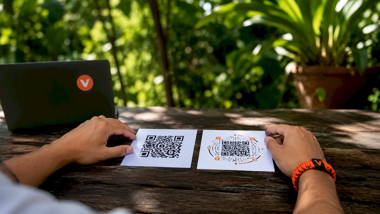 Twee handen die kaartjes vasthouden met zowel een statische als een dynamische QR-code erop.