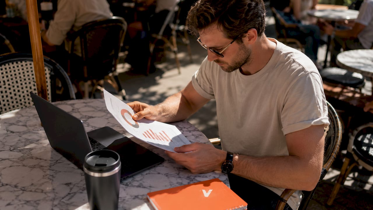 Een man bekijkt in een café het rapport met de scanfrequentie van QR-codes.