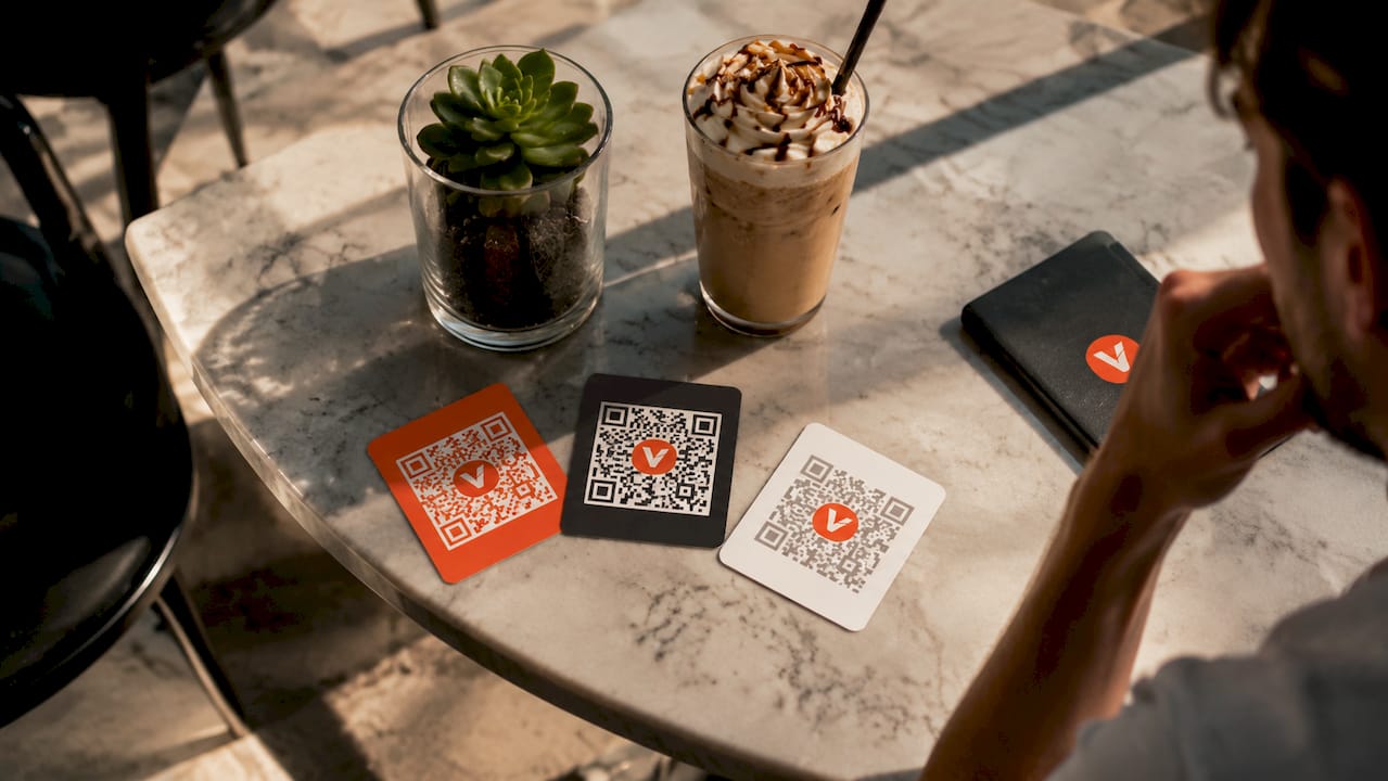 Op een horecatafel liggen drie verschillende QR-codes vlak naast elkaar.