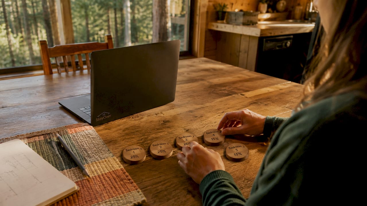 Hands arranging room cost tokens on cabin table