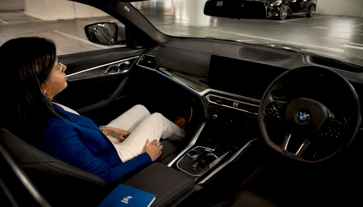 Professional woman seated inside BMW i4 company car
