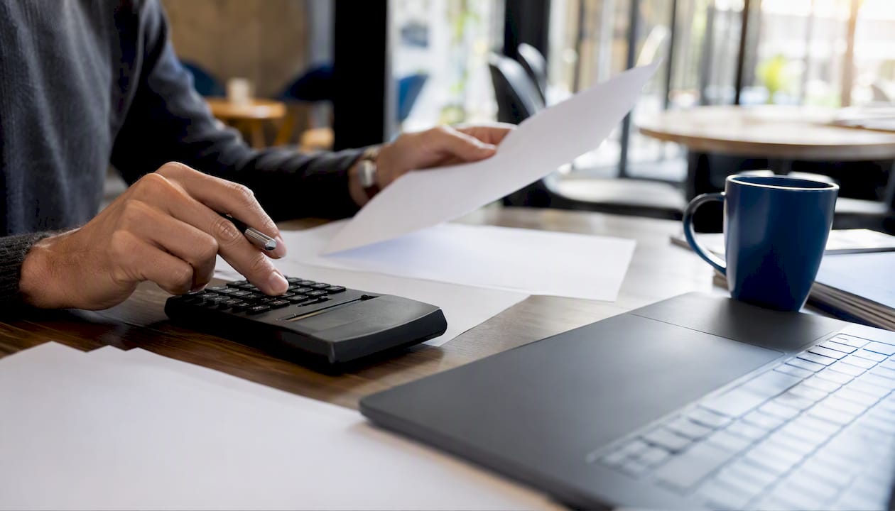 Hands calculating employer pension contributions
