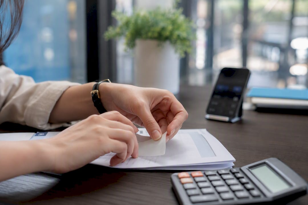 Hands tagging exchange rate on foreign invoice