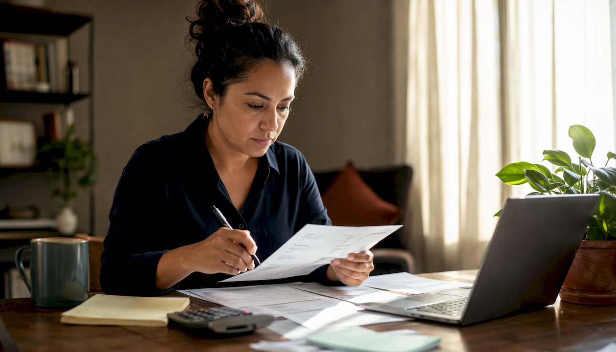Woman reviewing bank statements at home office