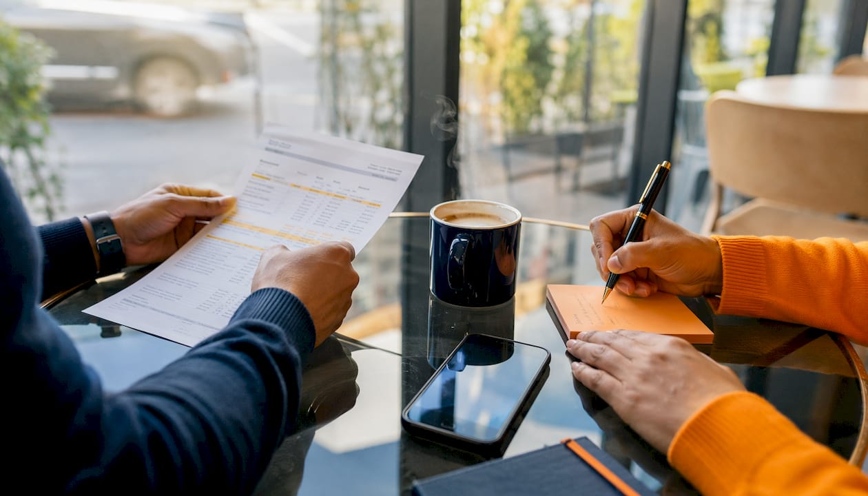 Hands reviewing bank statements for income calculation