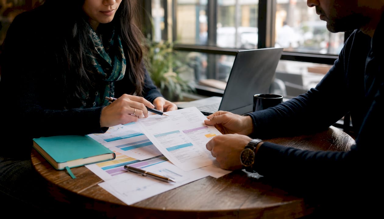 Hands of two people reviewing subcontractor invoices
