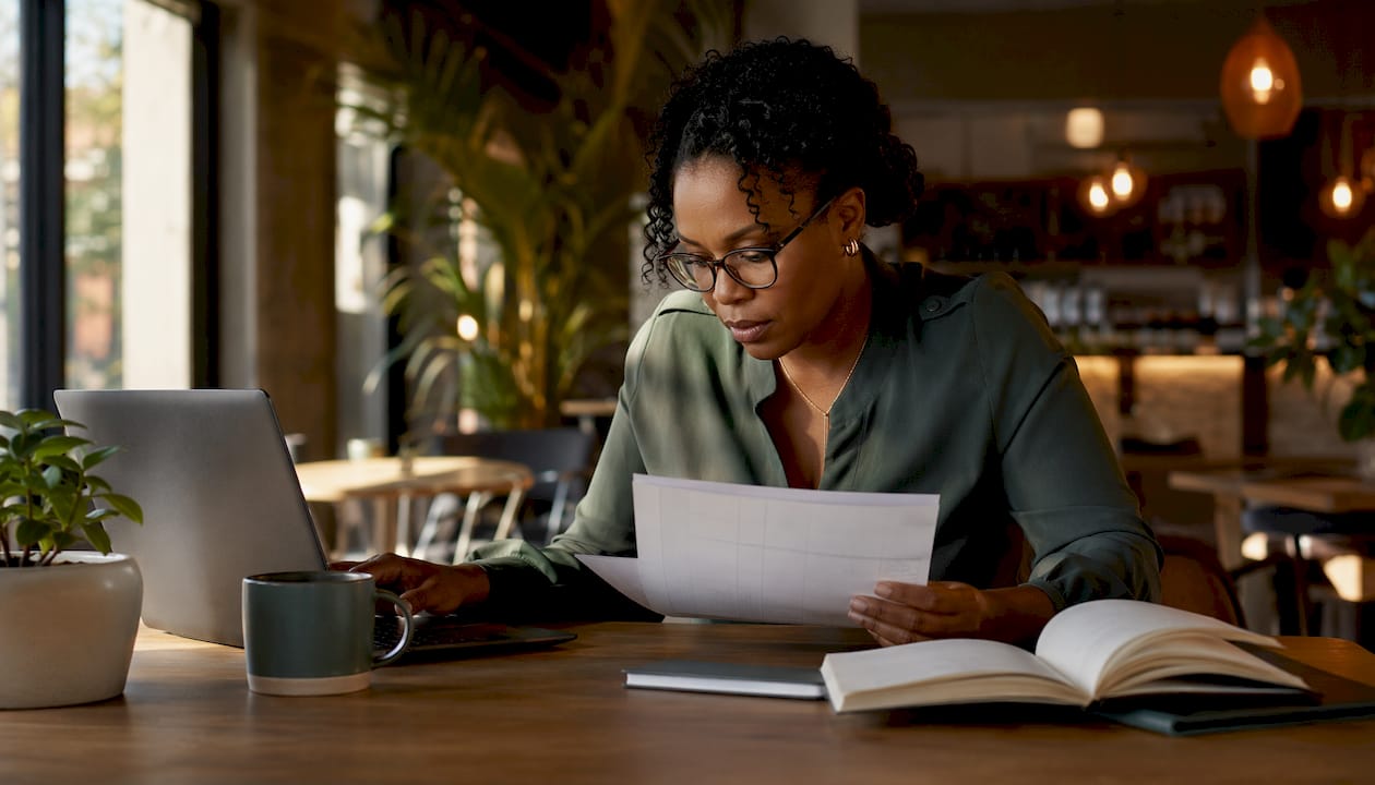 Woman reconciling inventory ledger with financial journal