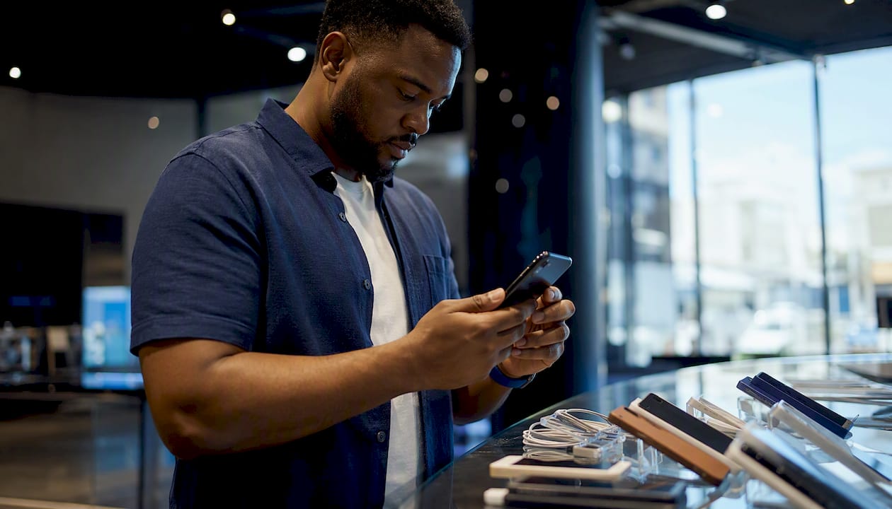 Hands inspecting refurbished smartphone in store