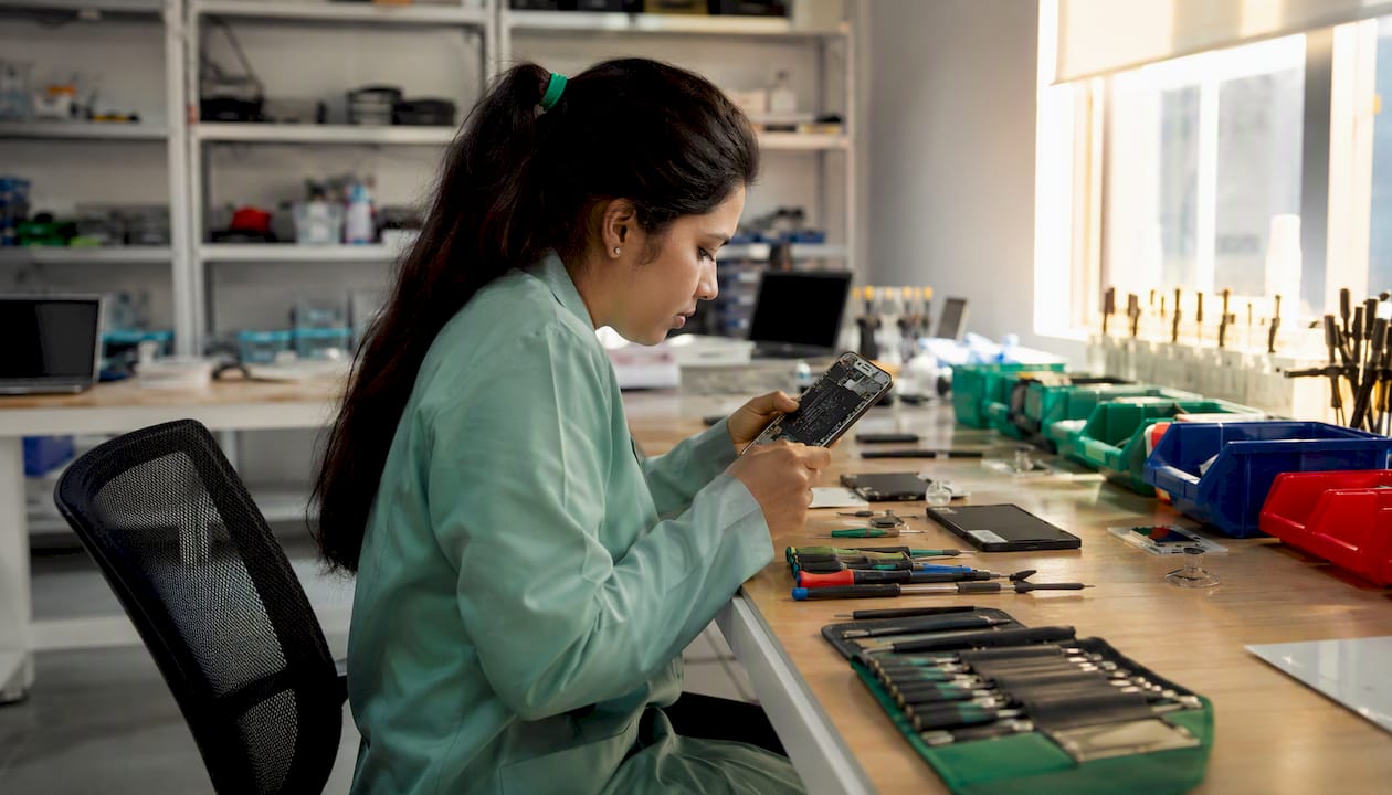 Technician examining smartphone for resale