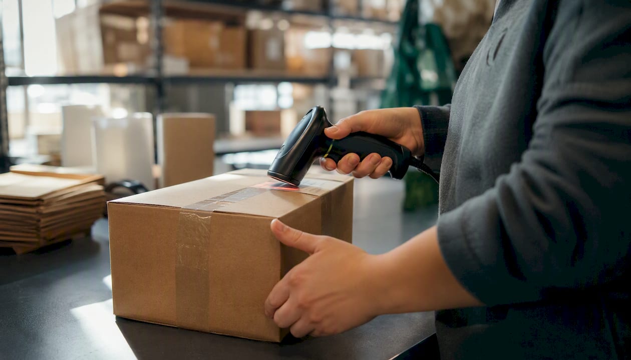 Hands scanning shipment barcode in warehouse