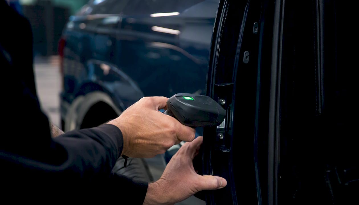 Hands scanning vehicle VIN plate