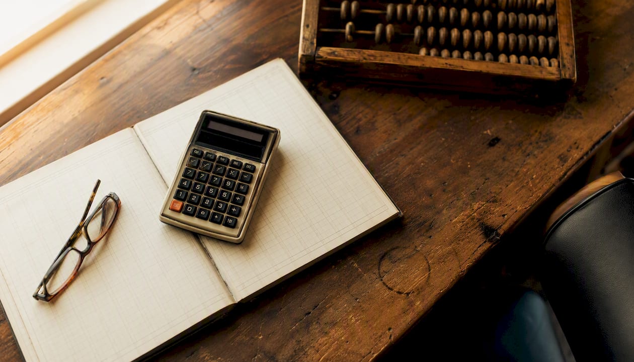 Calculator and financial tools on wooden desk