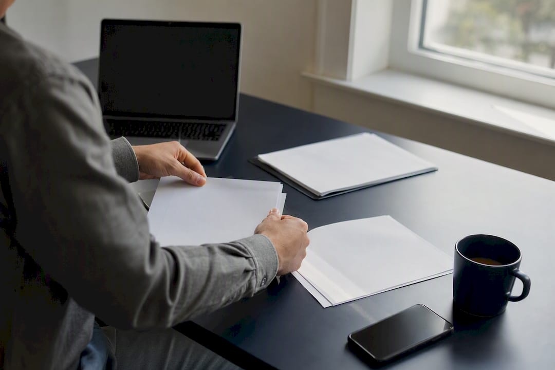 Hands organizing bank statements and profit-loss document