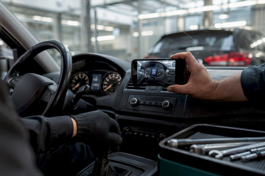 Technician photographing vehicle odometer for audit