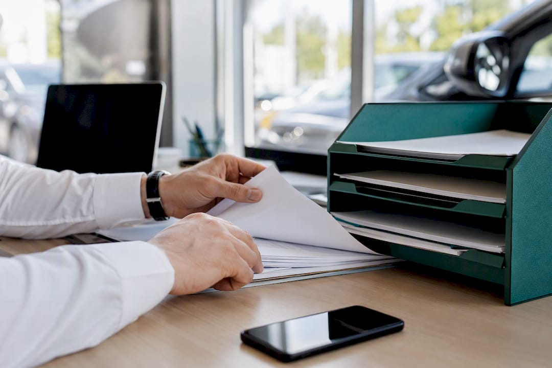 Dealer hands handling automotive deal documents