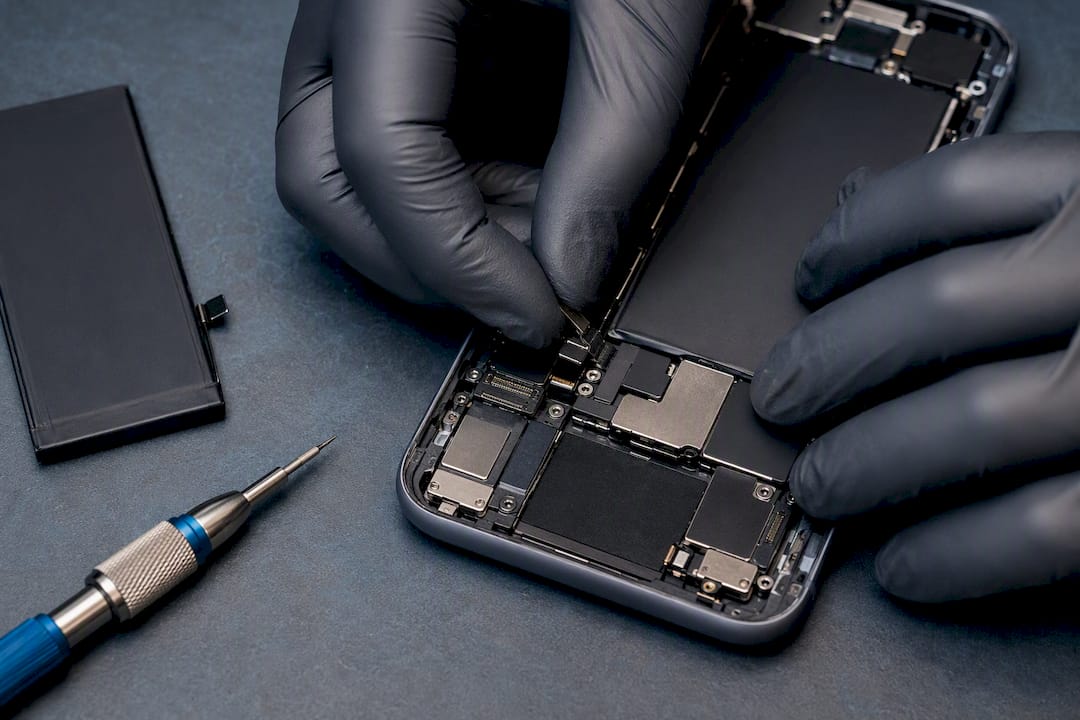 Technician inspecting an anonymous phone battery