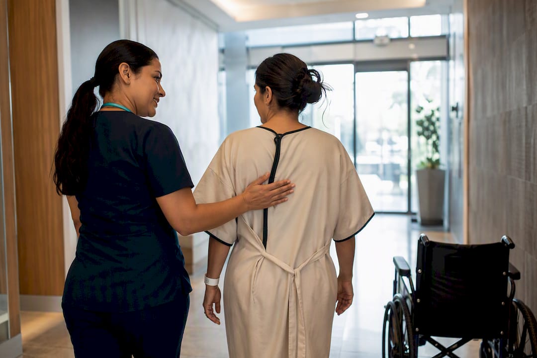 Nurse escorting patient toward pre-op check-in