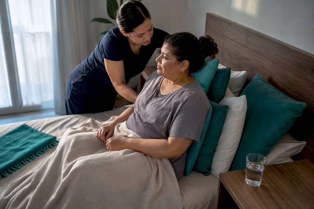 Caregiver helping patient settle during home recovery
