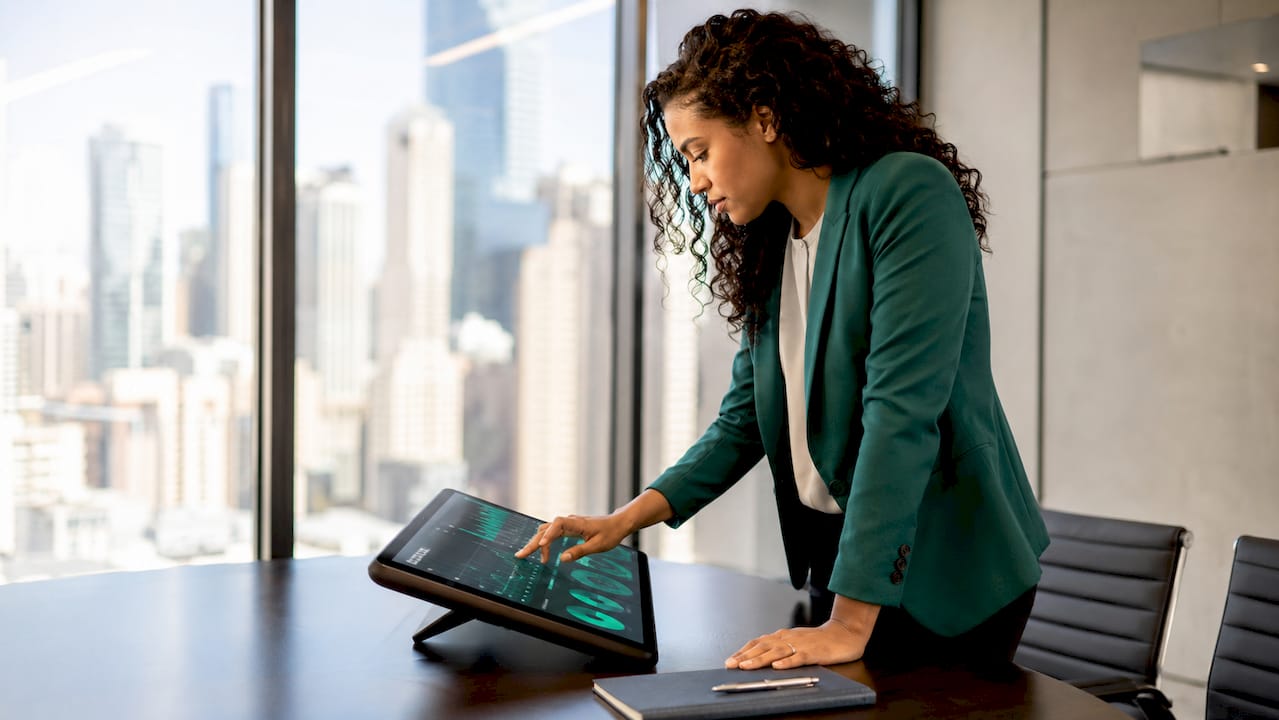 Hands interacting with touchscreen in conference room