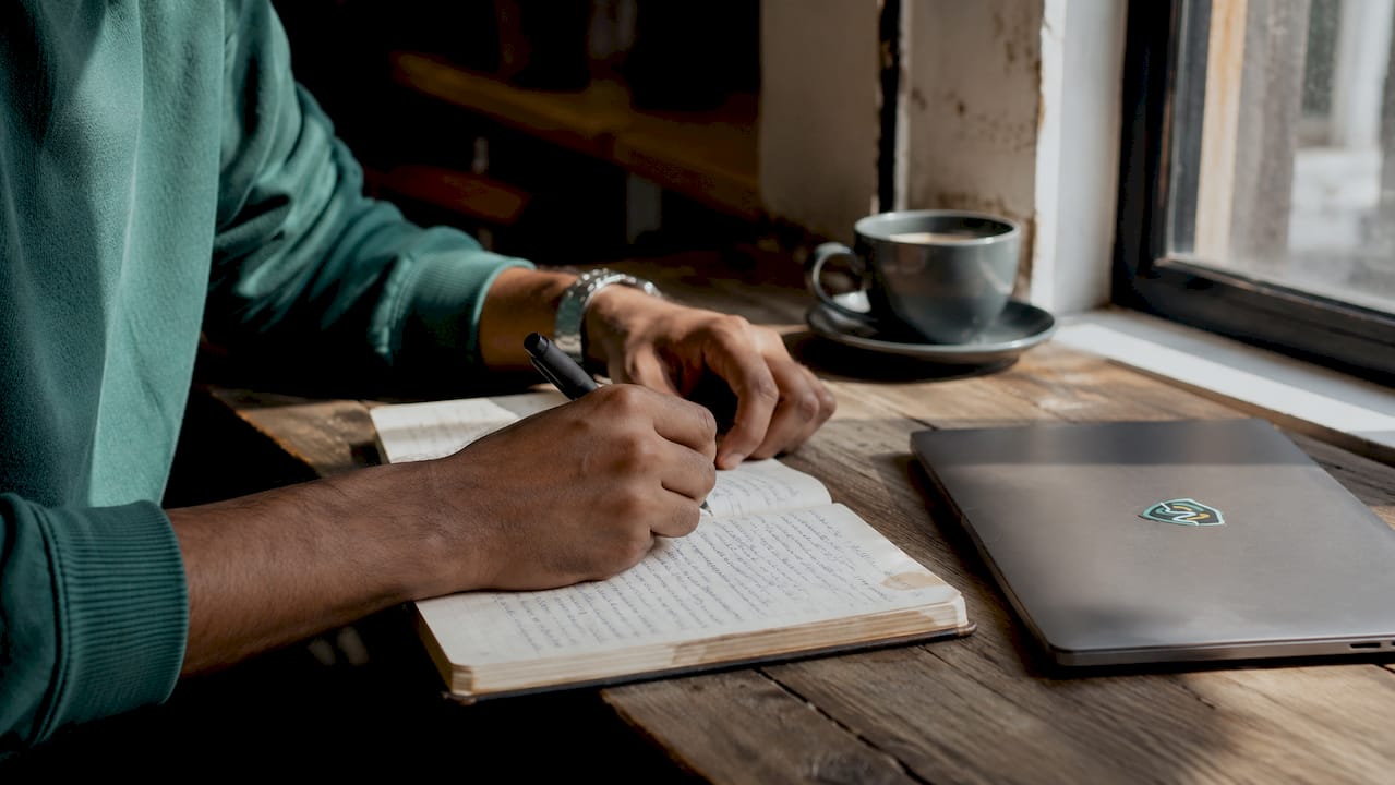 Hands typing and taking notes on identity theft