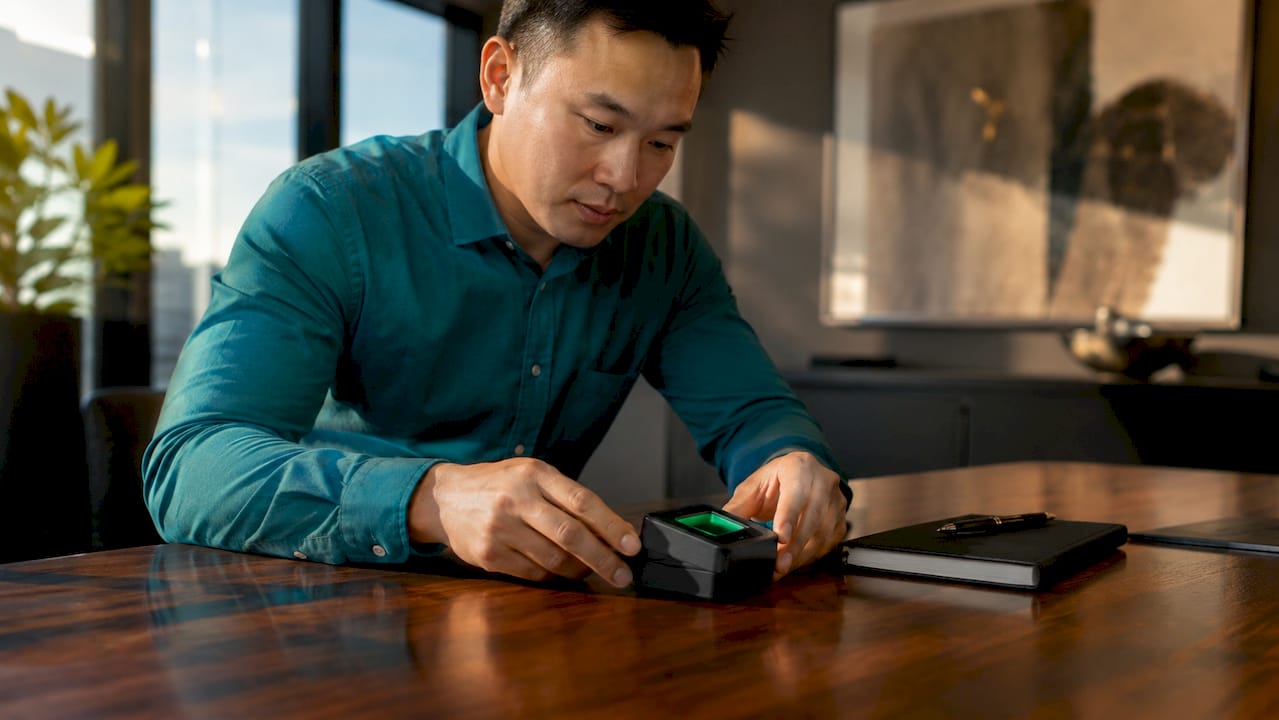 Hands setting up biometric verification device