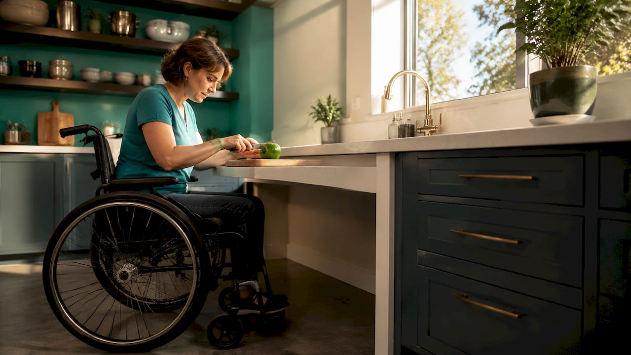 Wheelchair user at tiered kitchen countertop